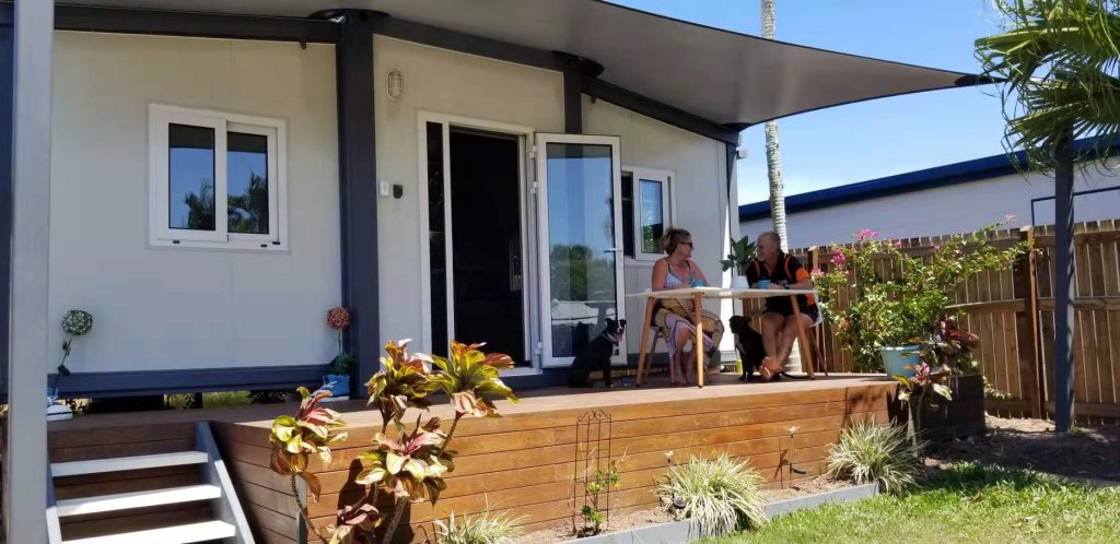 couple discussing business on small table sitting on verandah of a tiny small home