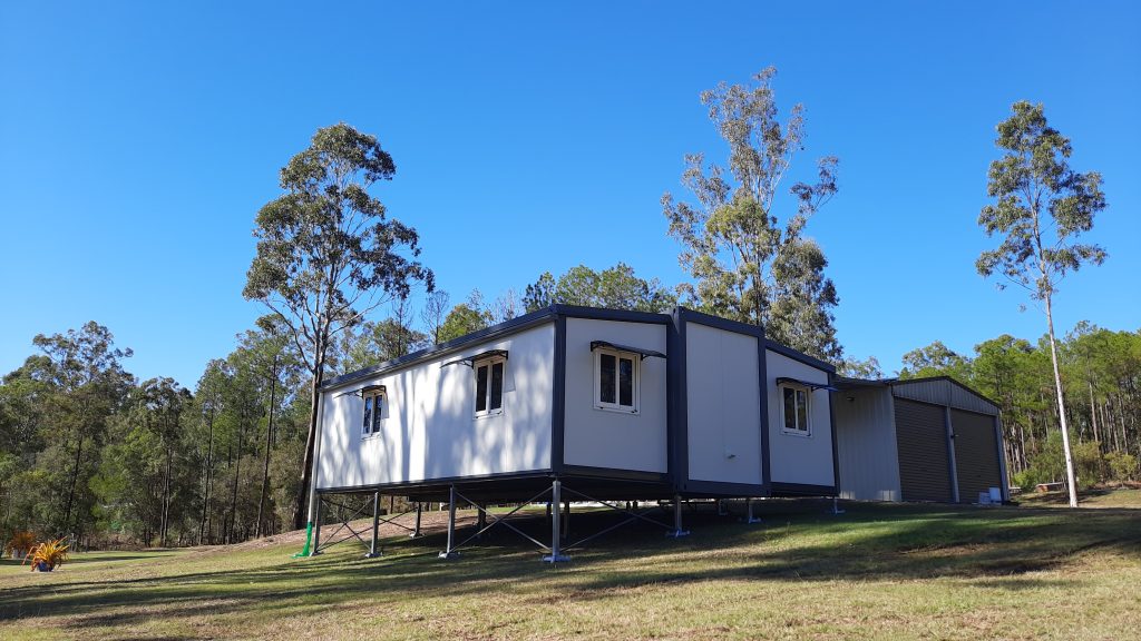 tiny home on uneven block of land with double garage shed