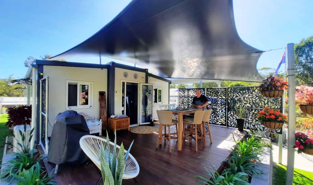 man enjoying fully set up tiny home, landscaped, bbq, deck, awning - awesome