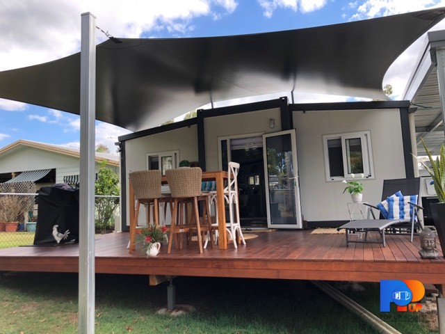 front view tiny / small home with deck and outdoor table bbq and sun lounge
